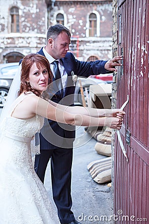 Newly wedding couple trying to open doors Stock Photo