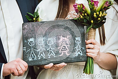 Newlywed couple is holding in hands picture of their future family they dream of Stock Photo