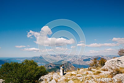 Newlyweds on the background of the panorama of the Kotor Bay. Beautiful view from Mount Lovcen Montenegro Stock Photo