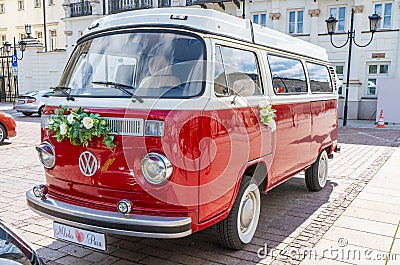 Newlyweds car. Red minibus volkswagen. Retro bus car. Decorated with bouquets of flowers. Festive decor, bridal bouquet Editorial Stock Photo