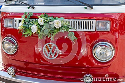 Newlyweds car. Red minibus volkswagen. Retro bus car. Decorated with bouquets of flowers. Festive decor, bridal bouquet Editorial Stock Photo