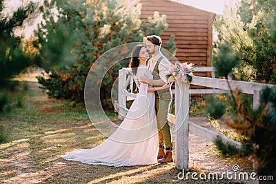 Newlyweds in cowboy style standing and hugging on ranch Stock Photo