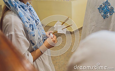 newlyweds in embroidered clothes hold lighted candle in church. wedding. close up. Stock Photo