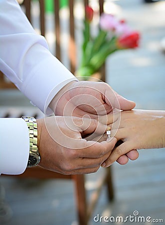 Newlyweds exchange rings, groom puts the ring on the bride's hand Stock Photo