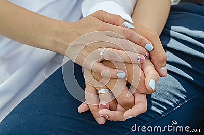 The hands of the bride and groom are intertwined in a tight knot. Wedding ceremony. Stock Photo