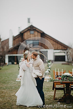 Newlyweds kiss on background of banquet table Stock Photo