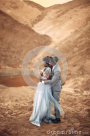 Newlyweds stand and hug in canyon against background of river. Stock Photo