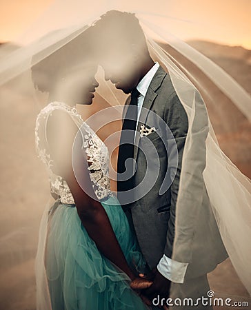 Newlyweds stand under bridal veil and hold hands in canyon at sunset. Stock Photo