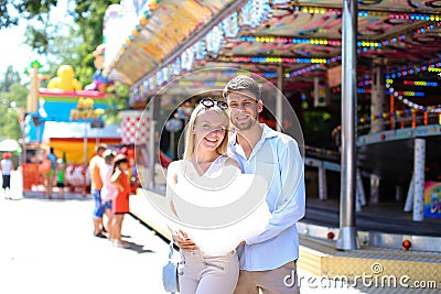 Newlyweds strolling in luna park, looking at each other, cuddlin Stock Photo