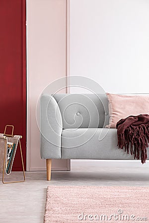 Grey couch in bright living room interior with three colored wall, real photo Stock Photo