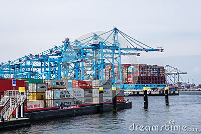 New container terminal with a large container ship and in the foreground a smaller inland container ship in the port of Rotterdam Editorial Stock Photo