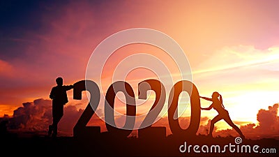 2020 Newyear Couple tries to push number of 2020 Happy new year concept Stock Photo