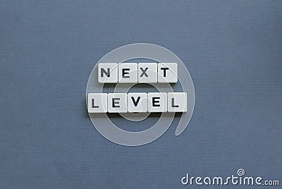 ' Next Level ' word made of square letter word on grey background Stock Photo