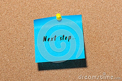 Next step words written on blue sticker pinned at notice board Stock Photo