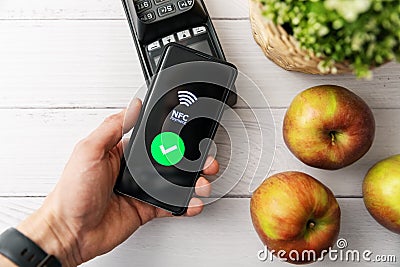 Nfc contactless payment with phone at groceries store Editorial Stock Photo