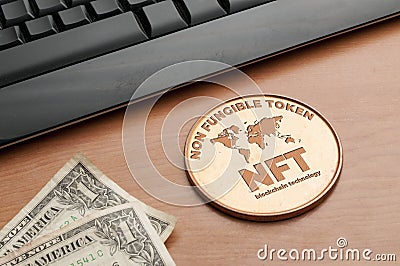 Nft non fungible token concept: big copper coin on a wooden table with a computer keyboard and two dollar bills Stock Photo