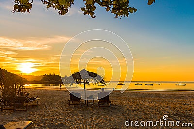 NGAPALI, MYANMAR - DECEMBER 5, 2016: Sunset on the beach, deck chairs with an umbrella. Copy space for text. Editorial Stock Photo