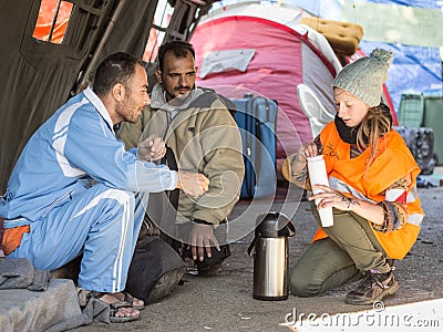 NGO Volunteers providing assistance to two refugee men waiting to cross the Serbia Croatia border Editorial Stock Photo