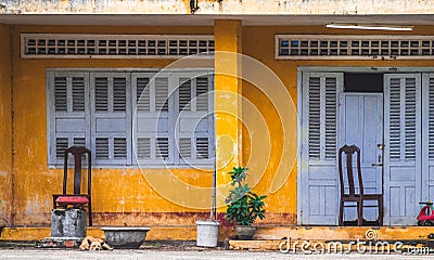 Nha Trang, Vietnam - January 4, 2019: The facade of the house is yellow with closed wooden shutters on the windows Editorial Stock Photo