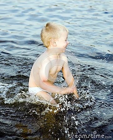 Nice boy swashes in water of the Baltic sea Stock Photo