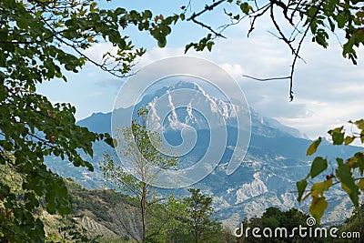 Nice breathtaking scenic panoramic view at green mountains landscape in sunny summer weather through foliage frame Stock Photo