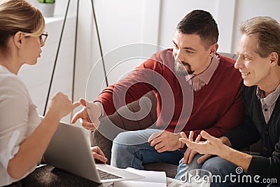 Nice cheerful gay couple looking at the laptop screen Stock Photo