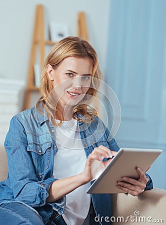 Pretty pleasant woman using her modern device and smiling Stock Photo
