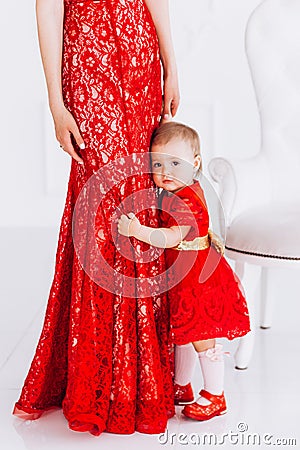Nice, family, good photo of mother and daughter in red dresses in the studio. Mother`s Day and daughters. Stock Photo