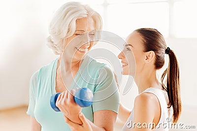 Nice fitness coach helping the elderly woman Stock Photo