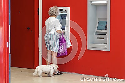 NICE , FRANCE - 15 August 2017 : an unidentified elderly lady makes a withdrawal at the cash desk in a bank near the Editorial Stock Photo