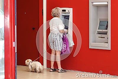 NICE , FRANCE - 15 August 2017 : an unidentified lady makes a withdrawal at the cash desk in a bank near the mall Editorial Stock Photo