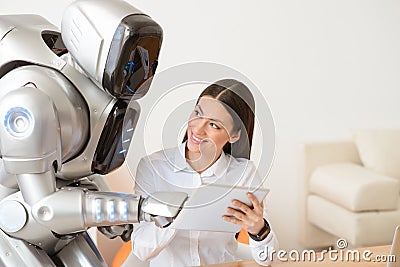 Nice girl using tablet with robot Stock Photo