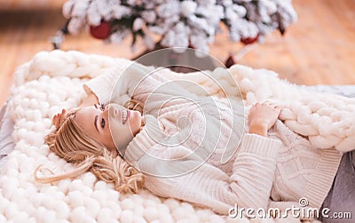 Nice happy woman lying on the knitted plaid Stock Photo