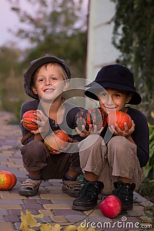 Nice kids sitting with Halloween pumpkins Stock Photo