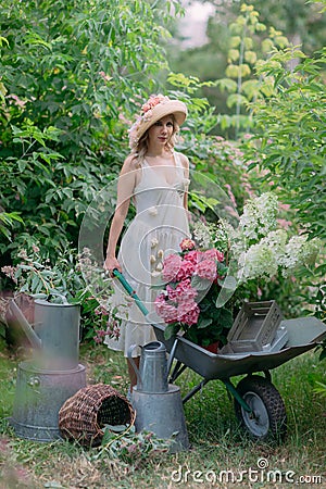 Nice lady a beautiful gardener with flower pots with hydrangea seedlings Stock Photo
