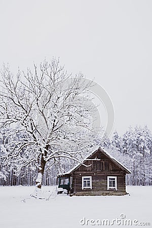 Nice old village house in the middle of beautiful winter with lots of white snow and trees. Stock Photo
