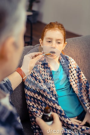 Nice pale girl taking the cough mixture Stock Photo