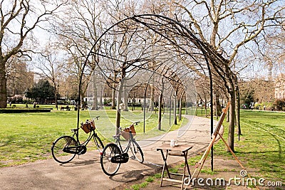 two Bicycles park arched entrance through walk way park. Stock Photo