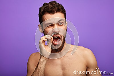 Nice pleasant man removing nose hair with tweezers Stock Photo