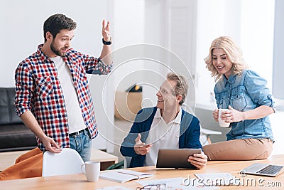 Nice pleasant man telling a story to his colleagues Stock Photo