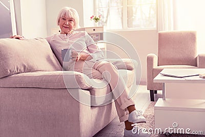 Nice positive pensioner wearing light fashionable clothes Stock Photo