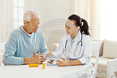 Nice professional doctor holding a box with pills Stock Photo