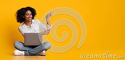 Happy Woman With Laptop Pointing At Copy Space Over Yellow Background Stock Photo