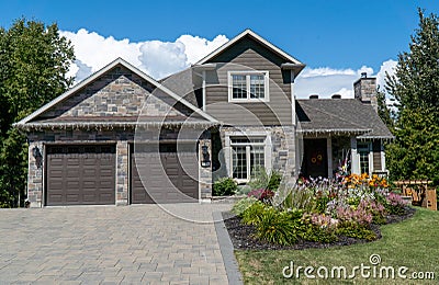 Nice single family house with nicely trimmed and landscaped front yard, lawn in a residential neighborhood. New Liskeard, Ontario Editorial Stock Photo