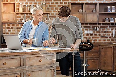 Senior man giving his young colleague advice about drawing Stock Photo