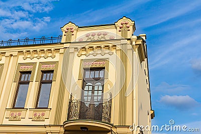 The facade of the house with a balcony and wrought-iron setting Stock Photo