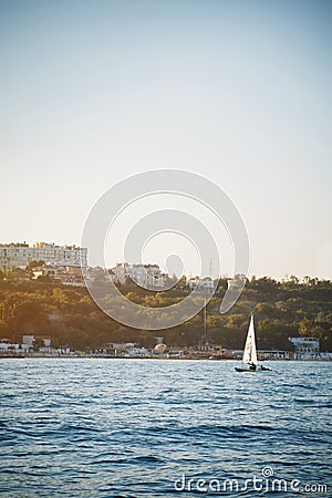 Nice view of small sailboat, yacht sailing in sunset at regatta Editorial Stock Photo