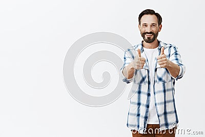 Nice work son, proud of you. Portrait of pleased and satisfied old man with beard in casual clothes, showing thumbs up Stock Photo
