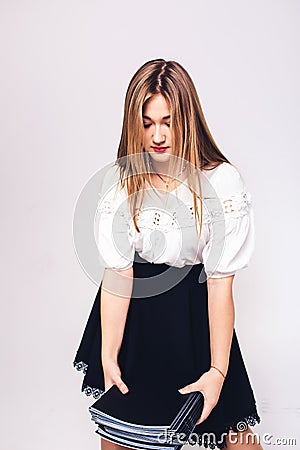 Nice young girl with a pile of magazines in her hands. Stock Photo