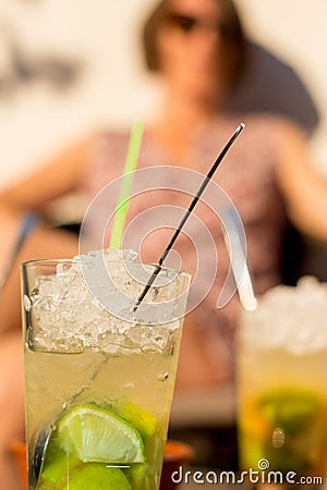 A nice young lady enjoys a mochito during sunset Stock Photo